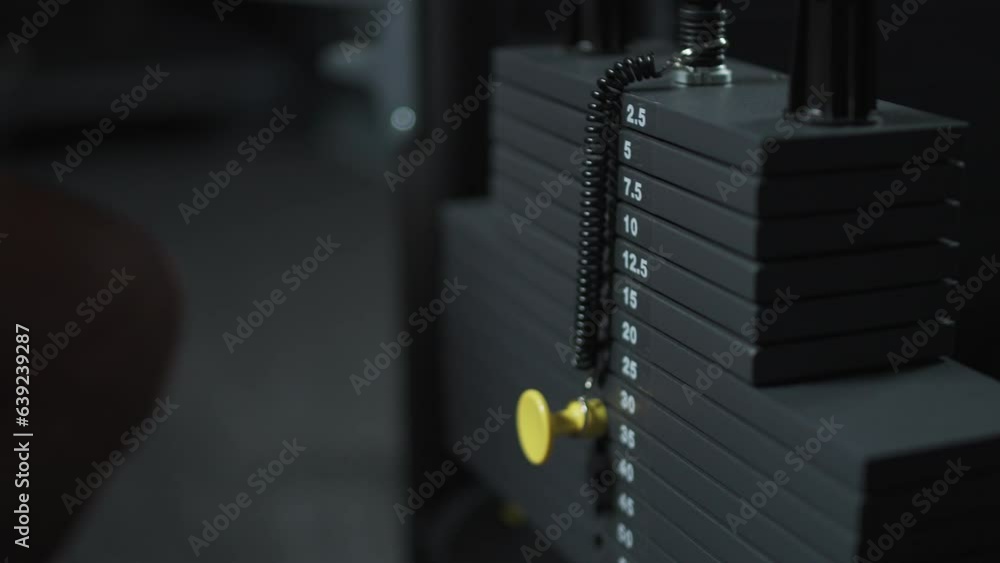 Anonymous athlete, sportsman chooses the weight on the gym machine, taking weight lifting in sport club. Anonymous athlete, sportsman chooses the weight on the gym machine, taking weight lifting in sport club.