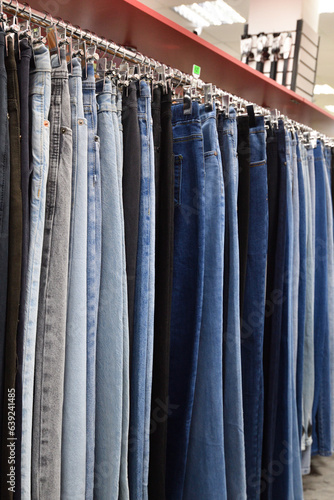 Jeans hanging in a row in a store