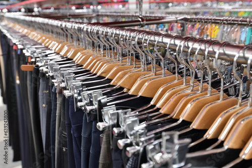Men's trousers hang in a row in a store