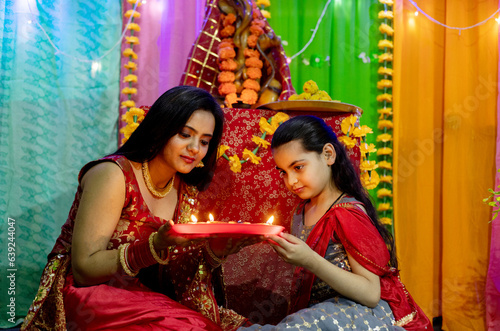 Indian Mother and Daughter decorating home with diya together, Celebrating festival at home