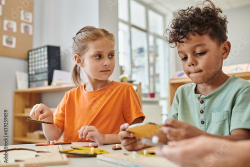 interracial children playing with didactic montessori material in school, learn through play, fun