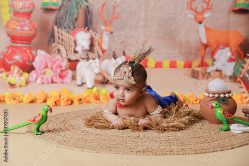 Janmashtami Concept. Cute baby boy dressed up as little krishna lying on floor. photo