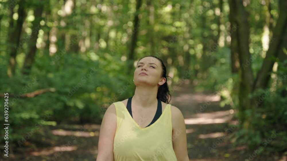 Sorting girl walks through the forest after a run listening to music in headphones. active lifestyle freedom and nature. High quality 4k footage Sorting girl walks through the forest after a run listening to music in headphones. active lifestyle freedom and nature. High quality 4k footage