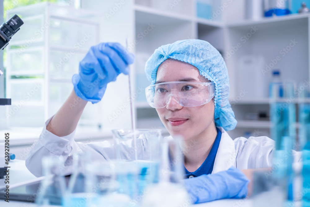 Fototapeta premium Professional woman specialist doctor laboratory white uniform use thermometer temperature on blue liquid in healthcare and medicine experiment equipment with glove care, young adult female scientist