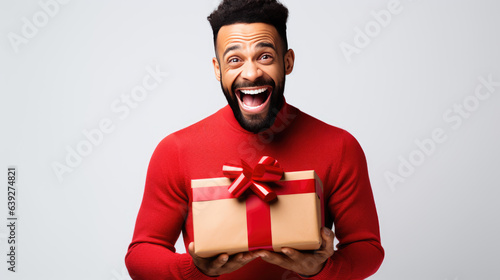 Happy smiling man holding gift box on a colored background