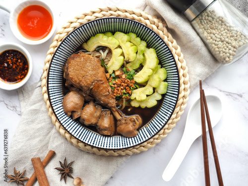 Noodle with braised chicken and  bitter melon in brown soup - Thai style of boat noodles called Kuay Teow Kai Toon at top view 