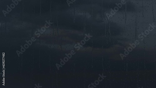 4K High quality footage of Rain on Window Sky Drops. Rain Drops Falling down on black background. Close up Slow Rain in slow motion. Droplets