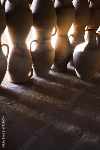 clay pots. Dark photography. Rays of light in the workshop