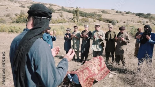 Muslim funerals during the war in Afghanistan. Pashtun men stand.