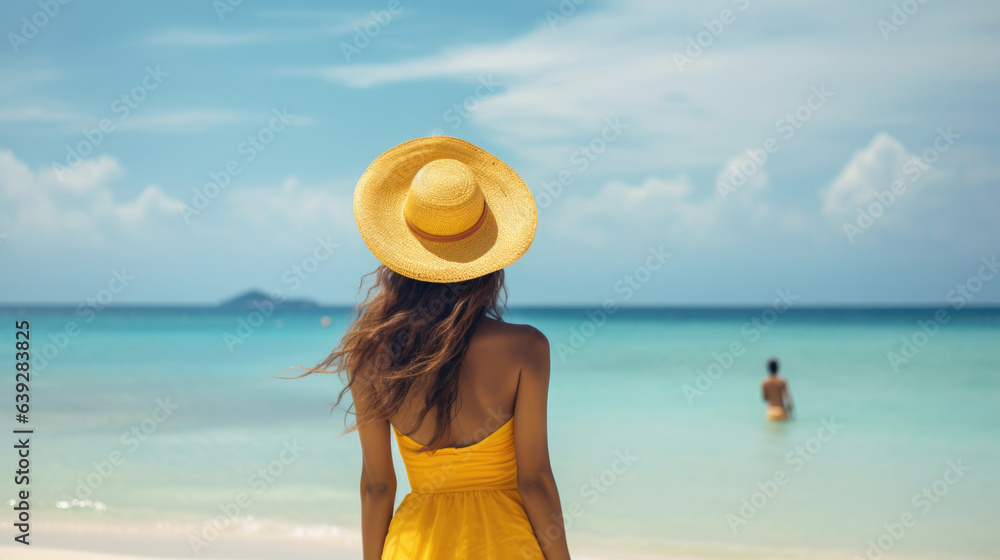 Summer vacation happy carefree joyful bikini woman arms outstretched in happiness enjoying tropical beach destination. Holiday girl sitting with sun hat relaxing from behind on Caribbean vacation.