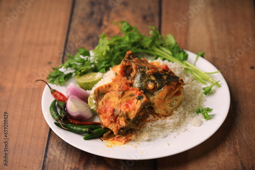 indian fish curry served with rice in a bowl closeup with selective focus and blur