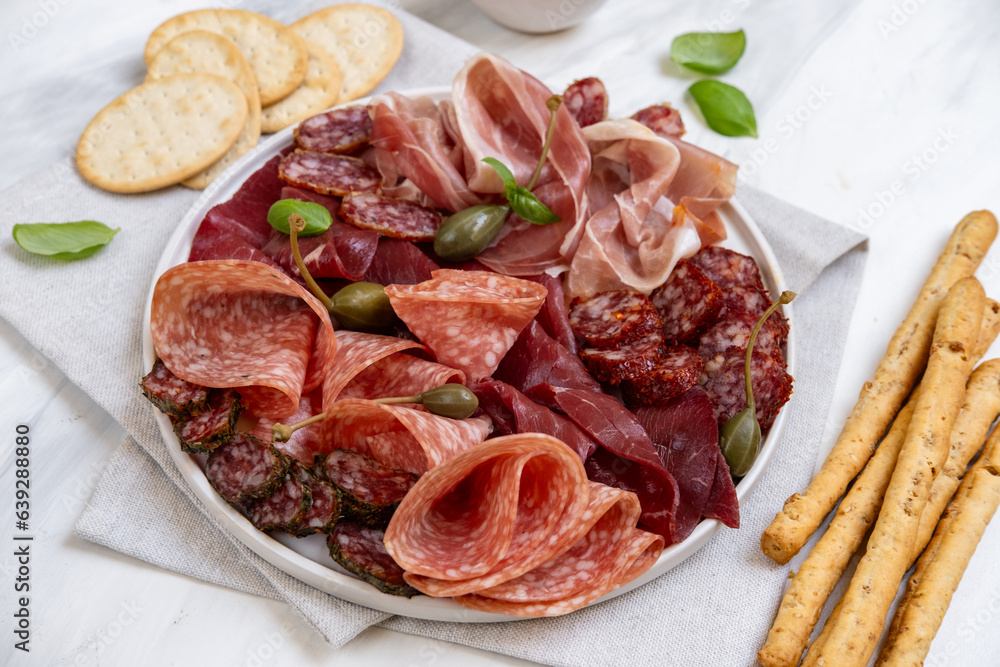 Food aperitif Italian prosciutto ham, parma ham, salami, bresaola beef olives and grissini breadstick. Charcuterie plate Food aperitif Italian prosciutto ham, parma ham, salami, bresaola beef olives and grissini breadstick. Charcuterie plate