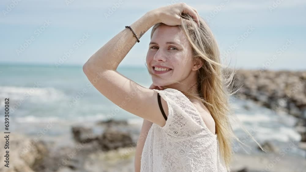 Young blonde woman tourist smiling confident touching hair at beach Young blonde woman tourist smiling confident touching hair at beach