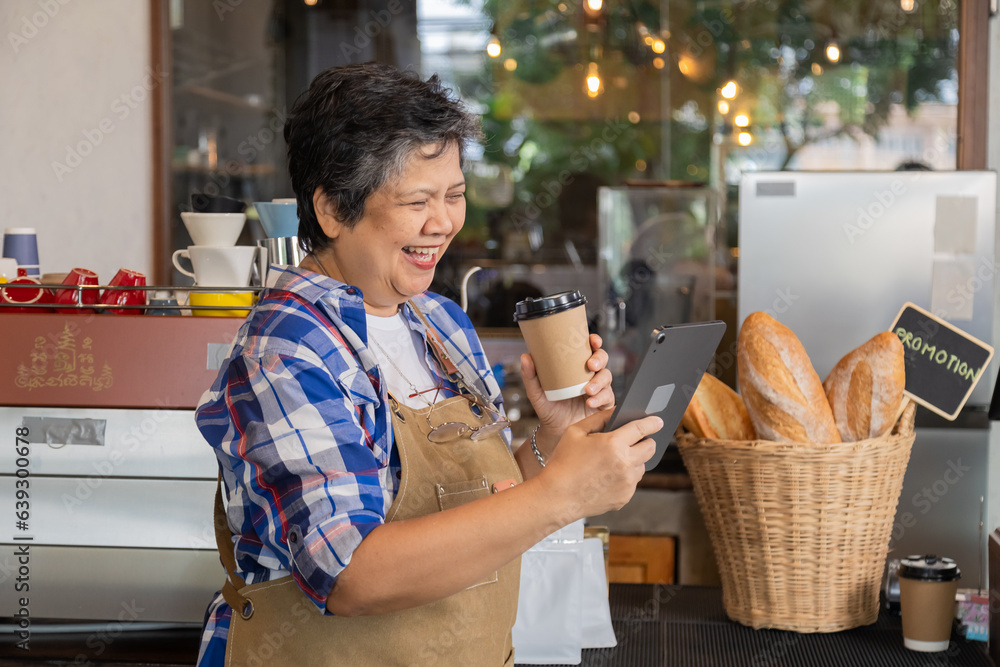 Fototapeta premium Happy aging society people lifestyle with modern technology tablet concept, Healthy Asian senior elderly retired woman coffee small business owner barista employee receive order by using application
