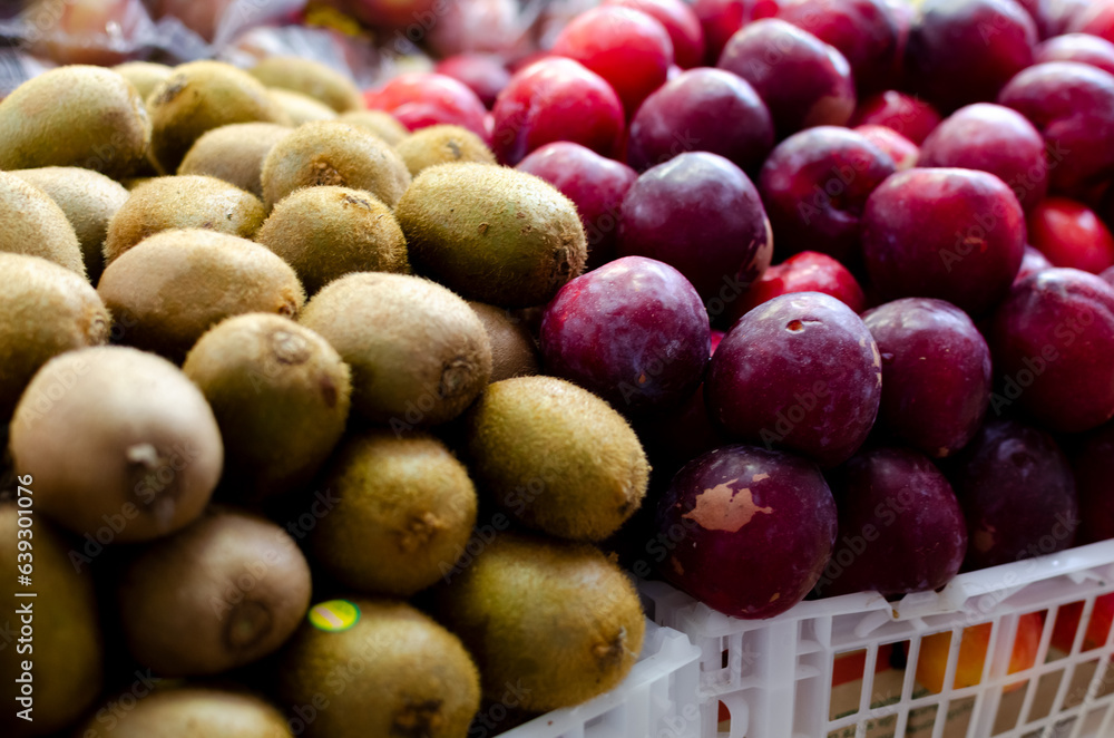 Sapotis and plums stacked on a table for sale. Healthy trade. Sapotis and plums stacked on a table for sale. Healthy trade.