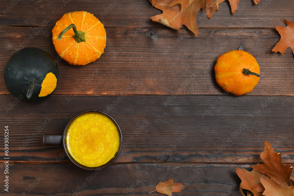 autumn background in rustic style, pumpkins, autumn leaves and golden milk drink on the table autumn background in rustic style, pumpkins, autumn leaves and golden milk drink on the table