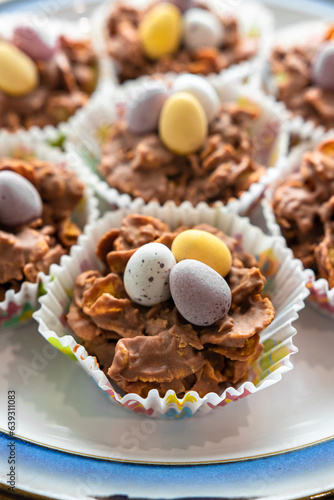 Easter cookies in paper baskets with colored eggs are placed on a white plate