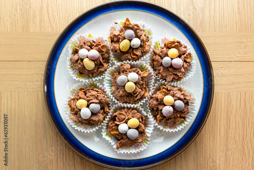 Easter cookies in paper baskets with colored eggs are placed on a white plate