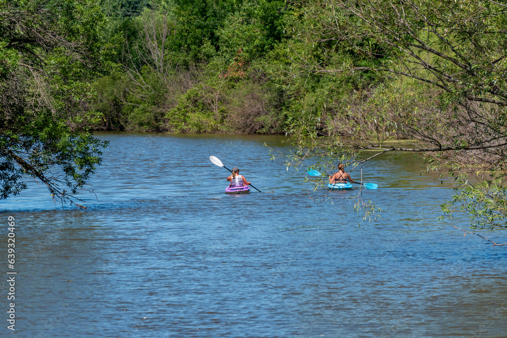 Two Women Kayaking On The River In Summer In Wisconsin