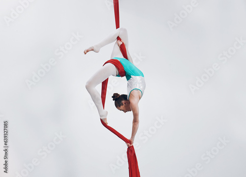 Aerial, woman gymnast fitness and sport performance with girl flexibility and athlete with white background. Workout, exercise and gymnastics with balance, art and dance with acrobat competition