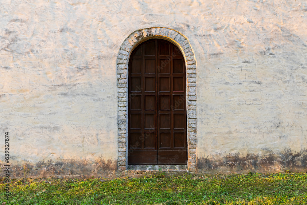 Vecchia porta di legno nel muro di pietra di una vecchia casa con erba. Vecchia porta di legno nel muro di pietra di una vecchia casa con erba.