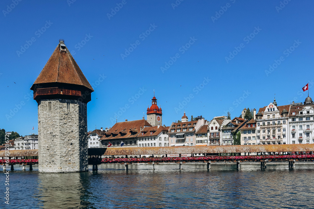 Obraz premium The Kapellbrucke (literally, Chapel Bridge), a covered wooden footbridge spanning the river Reuss diagonally in the city of Lucerne in central Switzerland