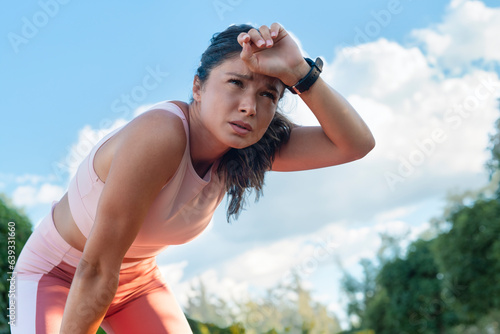 Low angle, female sports athlete tired after workout outdoor © Dexon Dee