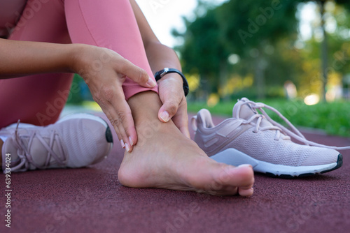 Obraz na plátně Young woman having pain in her ankle outdoor