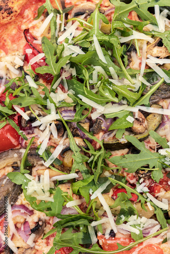 Close-up of an Italian pizza with cheese, mushrooms, onions, tomatoes, and herbs, food photo