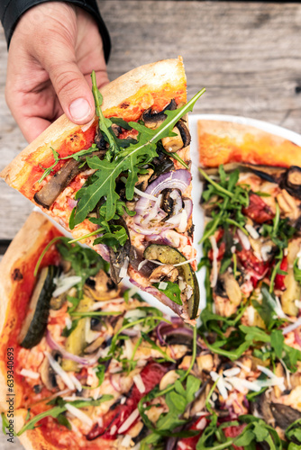 Close-up of an Italian pizza with cheese, mushrooms, onions, tomatoes, and herbs, food photo