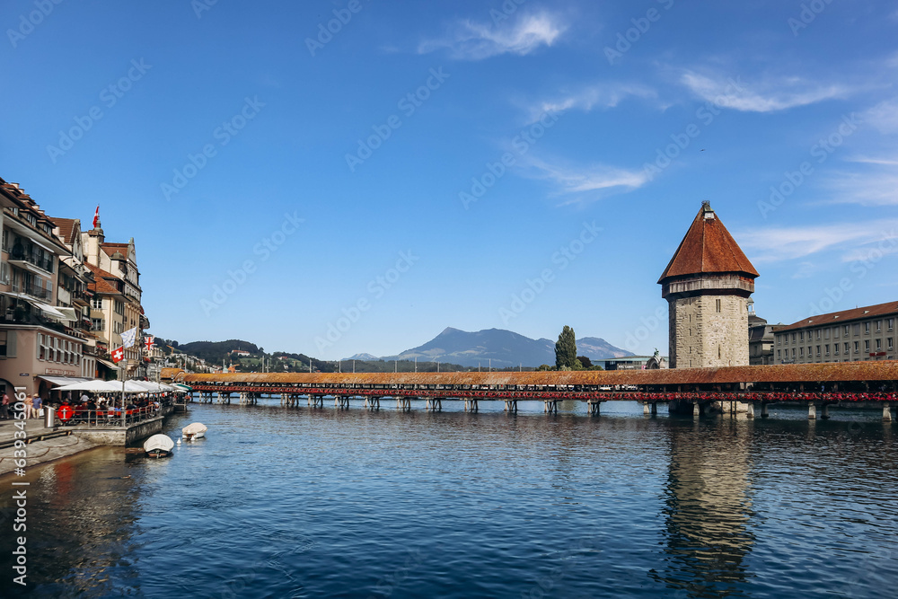 The Kapellbrucke (literally, Chapel Bridge), a covered wooden footbridge spanning the river Reuss diagonally in the city of Lucerne in central Switzerland