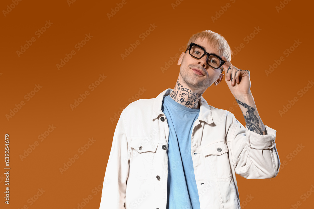 Young tattooed man in stylish eyeglasses on color background Young tattooed man in stylish eyeglasses on color background