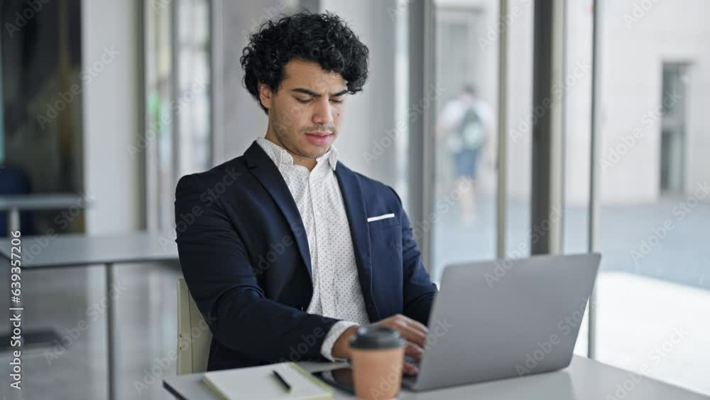 Young latin man business worker using laptop tired yawning at office Young latin man business worker using laptop tired yawning at office