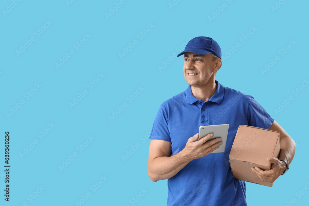 Mature courier with tablet computer and parcel on blue background Mature courier with tablet computer and parcel on blue background