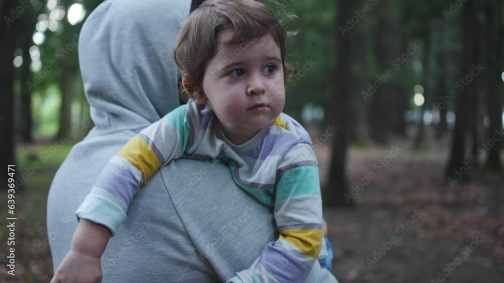 criminal portrait of a kidnapper with a child in his arms walks with his back to the camera in the woods close up criminal portrait of a kidnapper with a child in his arms walks with his back to the camera in the woods close up