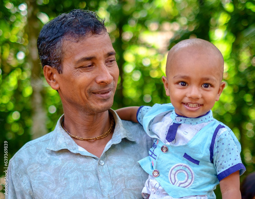 South asian rural grandfather holding his little grandson 