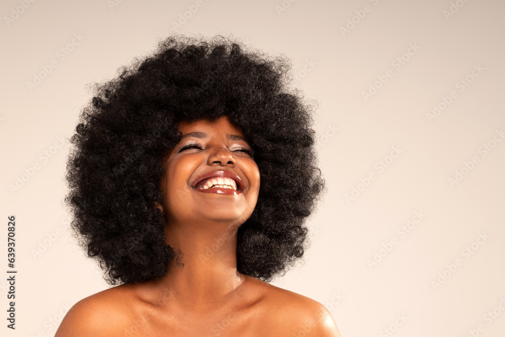 Studio portrait of young happy woman with afro hair and amazing toothy smile . Joyful girl posing in studio, expressing happiness and good mood. Studio portrait of young happy woman with afro hair and amazing toothy smile . Joyful girl posing in studio, expressing happiness and good mood.