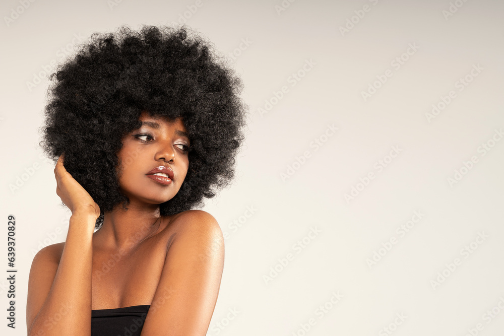 Beauty portrait of African American girl with amazing afro hair. Fashionable young woman with fresh glamour makeup.