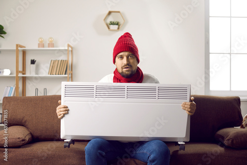Obraz na plátně Man freezing and trying to warm up when it's very cold in the house in winter