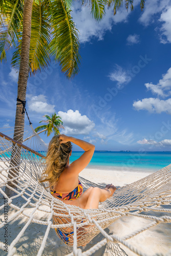 Best summer travel vacation. Happy traveler bikini woman relax in hammock on sunny beach coconut palms. Leisure carefree tropical paradise sky coast seashore. Wellbeing island recreational wallpaper