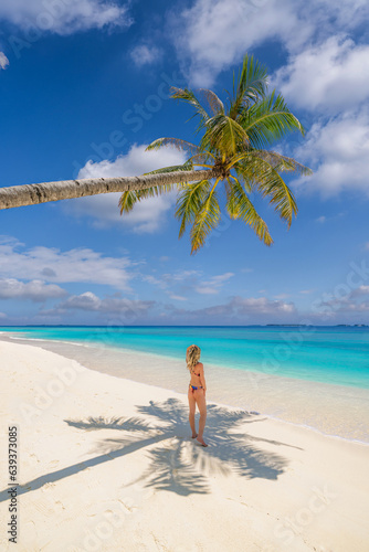 Beautiful carefree woman bikini suntan sunbathing  ocean tropical coast. Palm tree shadow on closeup sandy beach. Travel vacation paradise panoramic banner blue sea sky. Happy leisure summer lifestyle