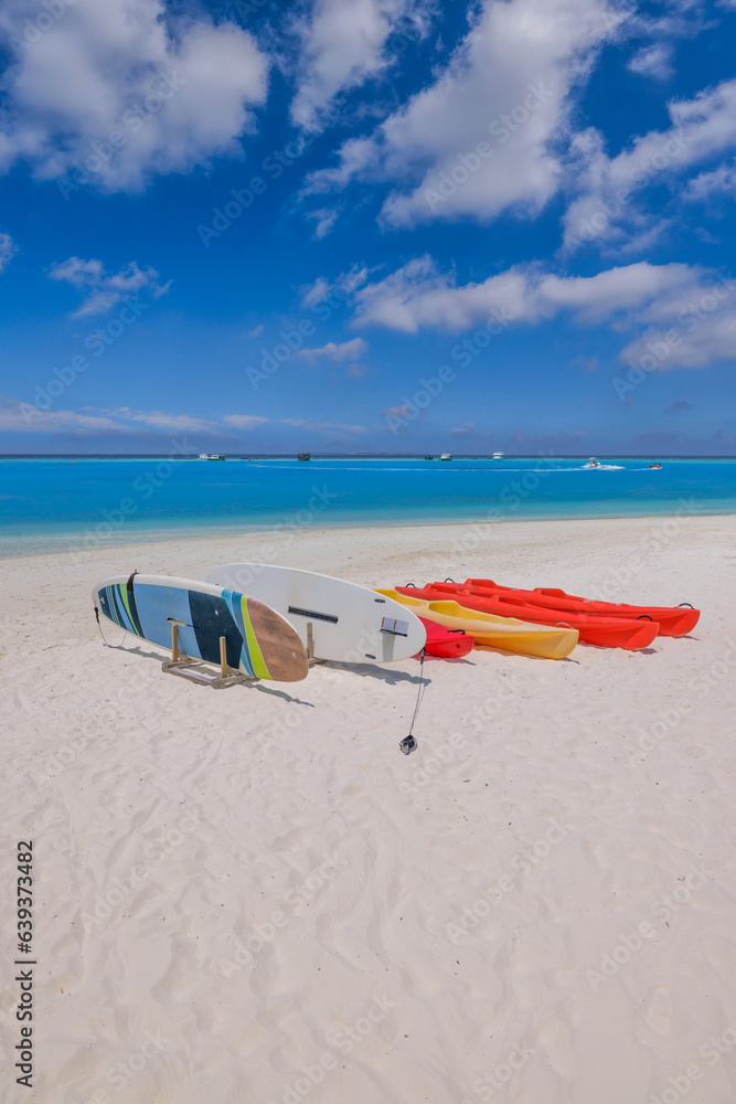 Beach coast in Maldives sea. Sup boards, kayaks close zo calm ocean bay water. Outdoor sport recreational equipment, fun wellbeing water activity. Sunshine, blue seascape sky, tropical resort Beach coast in Maldives sea. Sup boards, kayaks close zo calm ocean bay water. Outdoor sport recreational equipment, fun wellbeing water activity. Sunshine, blue seascape sky, tropical resort