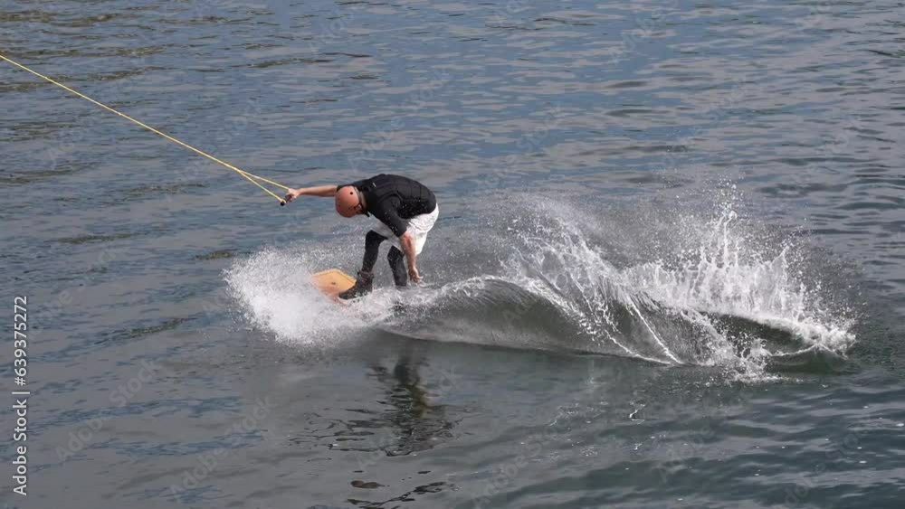 Wakeboarder ride on cable wakeboard in park, outdoor extreme on water, surfing athlete on water, young man riding a wakeboard on the river, Wakeboarder ride on cable wakeboard in park, outdoor extreme on water, surfing athlete on water, young man riding a wakeboard on the river,