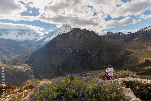 Woman photographer taking pictures in in the mountains at Huascaran National Park in Peru.