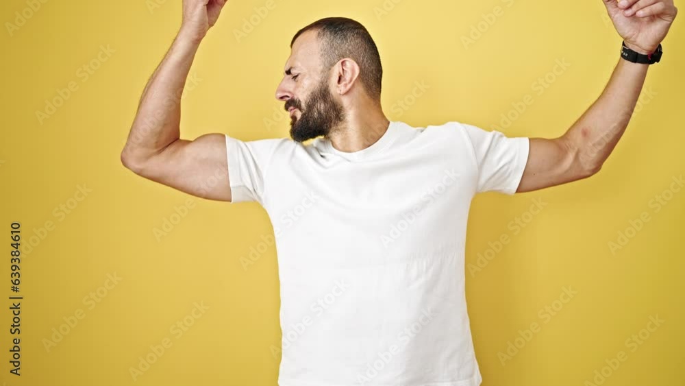 Young hispanic man doing strong gesture with arms smiling over isolated yellow background Young hispanic man doing strong gesture with arms smiling over isolated yellow background