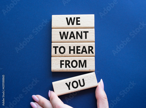 We want to hear from you symbol. Wooden blocks with words We want to hear from you. Beautiful deep blue background. Businessman hand. Business and We want to hear from you. Copy space.