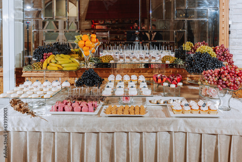 A delicious wedding. Candy bar with various chocolates. Fruit table. Celebration concept. Fashionable desserts. Table with sweets, candies.