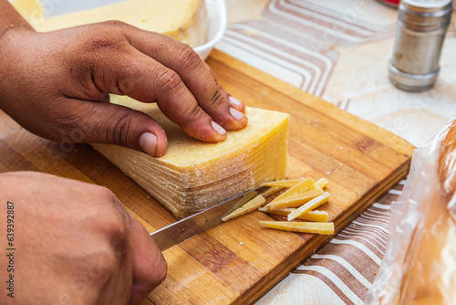 Fotografi Trimming the rind off a block of rumi cheese.
