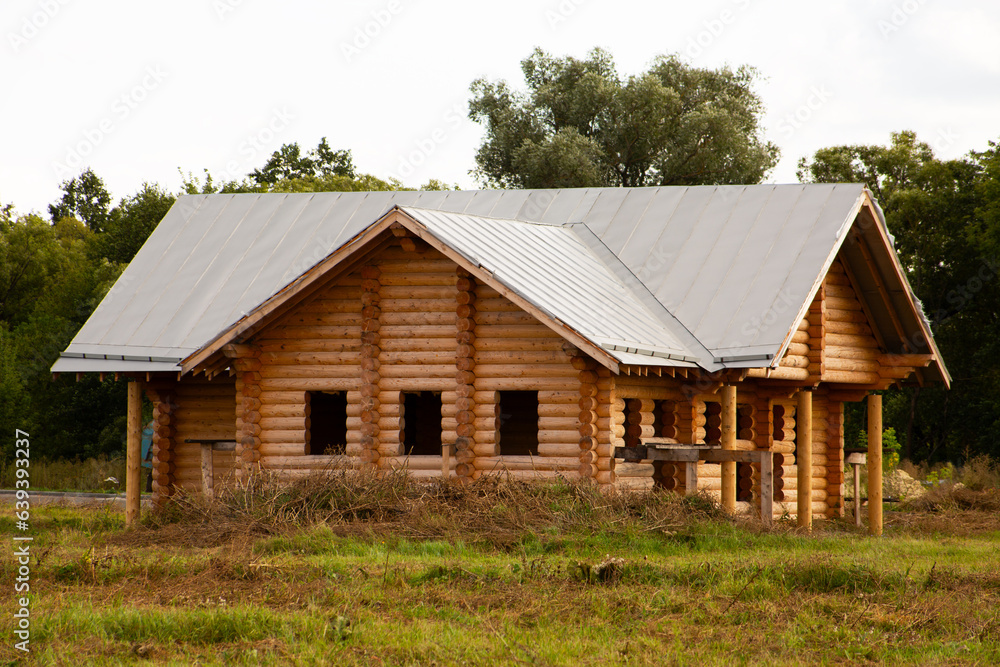 Log house under construction. Wooden house in the village without windows during construction in the summer Log house under construction. Wooden house in the village without windows during construction in the summer