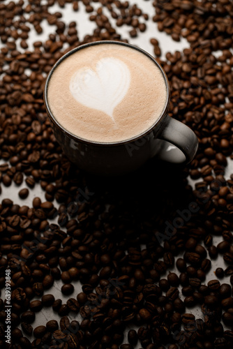 Tasty hot fragnant latte in white cup with beautiful heart pattern on foam